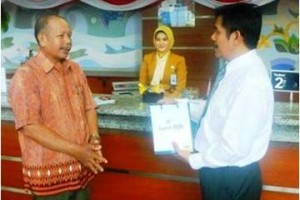 Pimpinan bjb cabang Kuningan, Wawan Mulyawan saat melayani pelanggan pada Hari Pelanggan Nasional 2014.